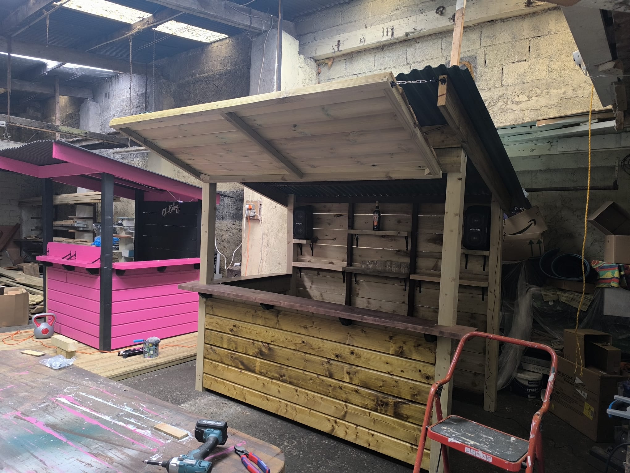 Garden bar with a slatted canopy roof, back-bar shelving and a stained counter